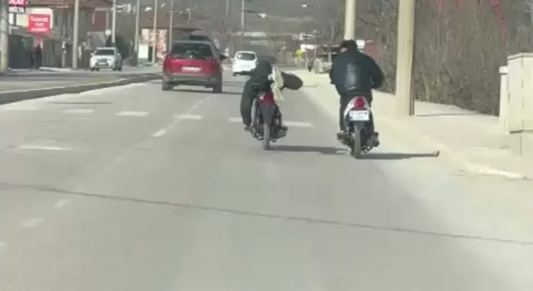 Kasksız sürücünün motosikleti yüzüstü yatarak kullandığı anlar kamerada
